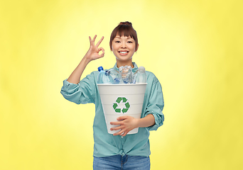 Image showing smiling young asian woman sorting plastic waste