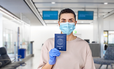 Image showing woman in mask and gloves holding immunity passport