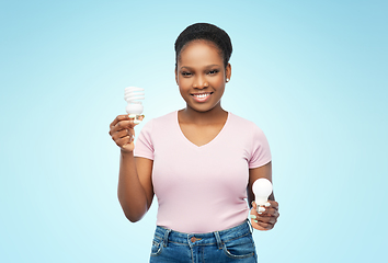 Image showing african american woman holding lighting bulbs