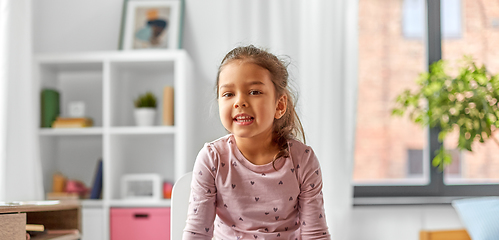 Image showing happy smiling little girl sitting on chair at home