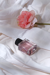 Image showing bottle of perfume and flower on white sheet