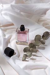 Image showing bottle of perfume and on white sheet