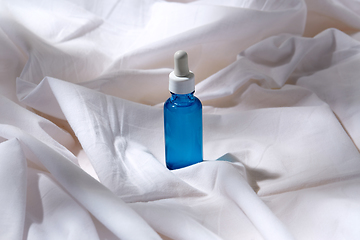 Image showing bottle of serum on white sheet