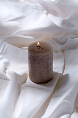 Image showing burning aroma candle on white sheet