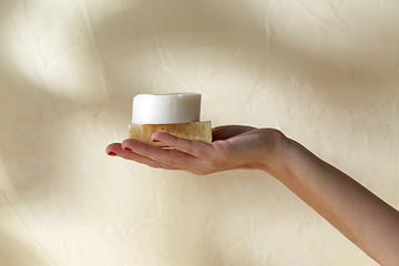 Image showing hand holding bar of craft soap on beige background