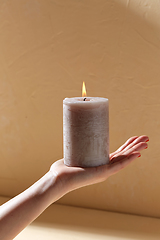 Image showing hand holding burning aroma candle on palm