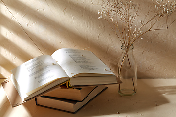 Image showing books and decorative dried flowers in glass bottle