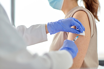 Image showing female doctor with syringe vaccinating patient