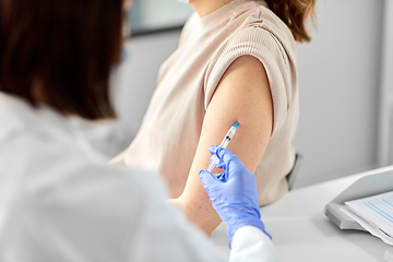 Image showing female doctor with syringe vaccinating patient