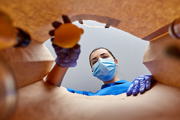 Image showing woman in gloves and mask with food in paper bag