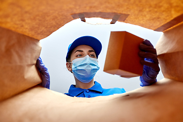 Image showing delivery girl in gloves and mask with food in bag