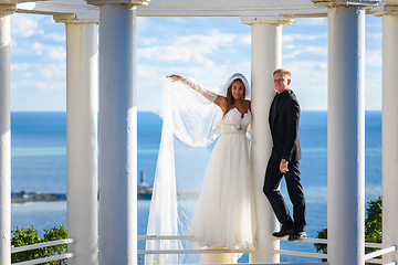 Image showing Newlyweds in a beautiful gazebo stand on a metal railing