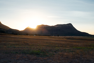 Image showing Sunset sunbeams sunburst as they hit the mountain edge