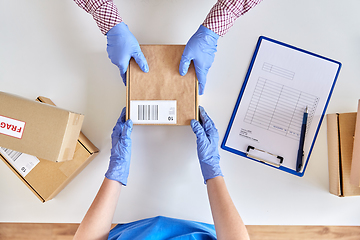 Image showing hands in gloves giving parcel box to customer