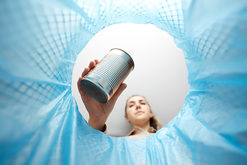 Image showing woman throwing tin can into rubbish bin