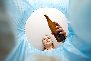 Image showing woman throwing glass bottle into trash can