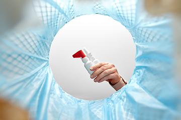 Image showing hand throwing old medicine into trash can