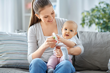 Image showing mother and little baby playing with rattle at home