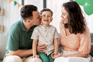 Image showing happy parents kissing little son at birthday party