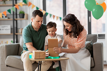 Image showing happy family opening birthday presents at home