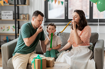 Image showing happy family with gifts and party blowers at home