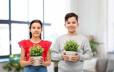 Image showing happy smiling children holding flower in pot