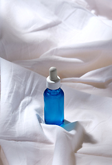 Image showing bottle of serum on white sheet