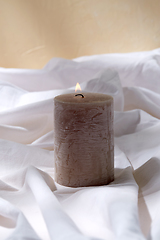 Image showing burning aroma candle on white sheet
