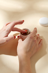 Image showing close up of hands with natural body scrub in jar