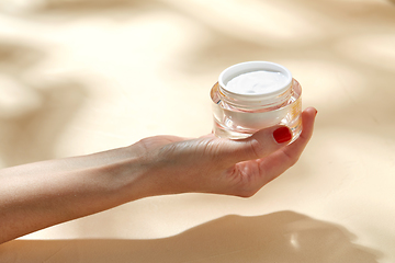 Image showing female hand holding jar of moisturizer