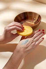 Image showing hands applying blue cosmetic clay mask to skin