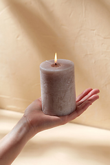 Image showing hand holding burning aroma candle on palm