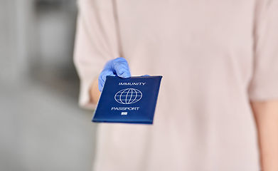 Image showing woman in glove holding immunity passport