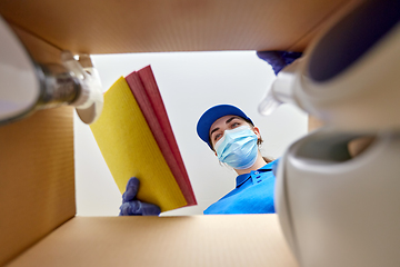 Image showing woman in mask packing cleaning supplies in box