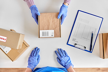 Image showing hands in gloves giving parcel box to customer