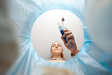 Image showing woman throwing toothbrush into trash can