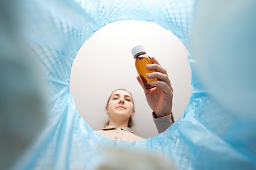 Image showing woman throwing old medicine into trash can