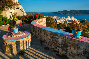 Image showing Picturesque scenic view of Greek town Plaka on Milos island over red geranium flowers