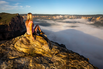 Image showing Woman hiker sitting high in mountain taking in magnificent views