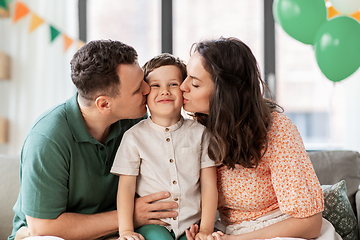 Image showing happy parents kissing little son at birthday party