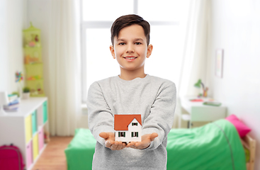 Image showing smiling boy holding house model