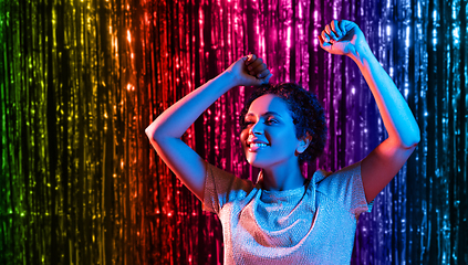 Image showing african american woman dancing over neon lights