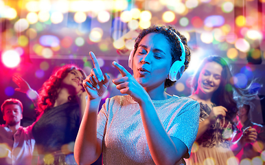 Image showing woman in headphones dancing at nightclub