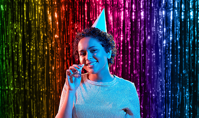 Image showing african woman in party cap with blower over black