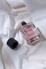 Image showing bottle of perfume and cap on white sheet