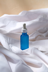 Image showing bottle of serum on white sheet