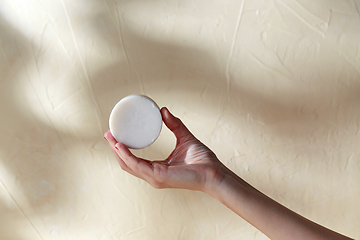 Image showing hand holding bar of craft soap on beige background