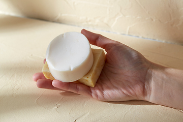 Image showing hand holding bar of craft soap on beige background