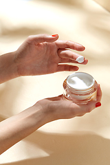 Image showing female hand holding jar of moisturizer