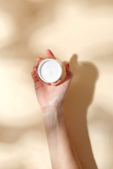 Image showing female hand holding jar of moisturizer